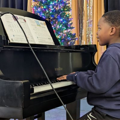 child playing piano during children's piano music lesson with ANAM Georgia | Agape National Academy of Music Georgi